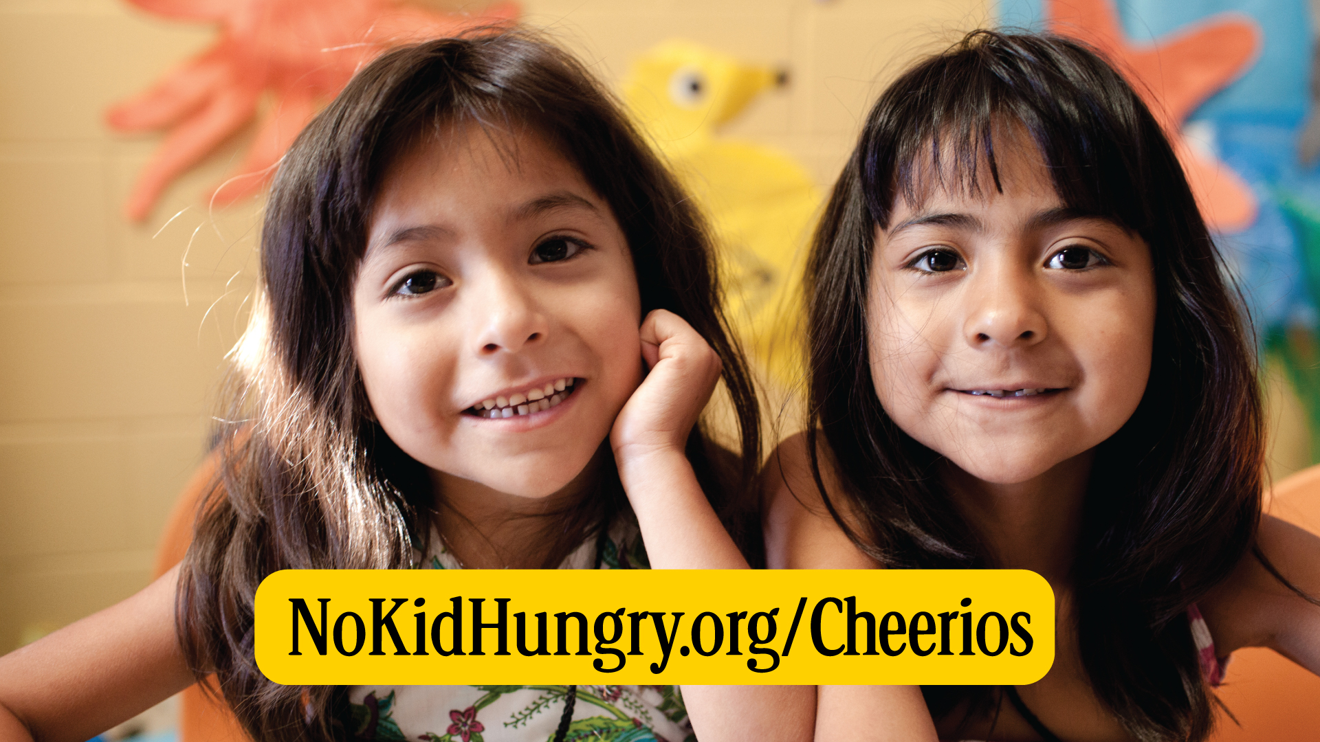 Two girls with nokidhungry.org/Cheerios